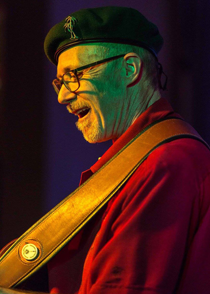 Mark Frederick Fisher plays and performs. Colorful photo with colored lights